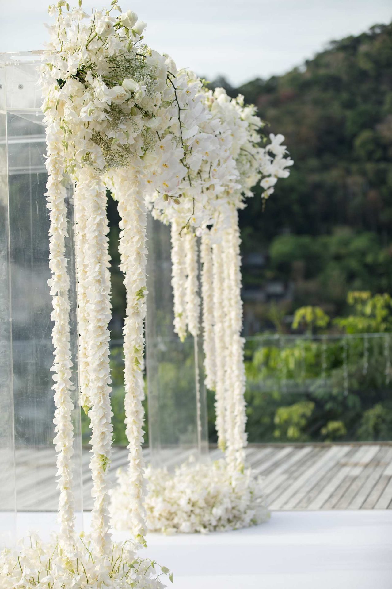 Cascading white phalaenopsis orchid ceremony arch overlooking the Andaman sea at Villa Santisuk, designed by Wedding Flowers Phuket