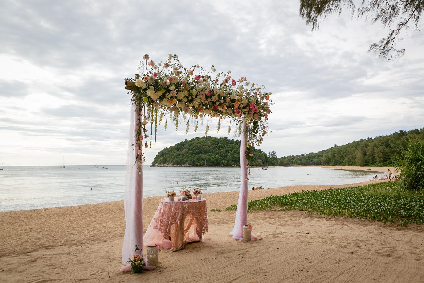 Driftwood and dried-grass ceremony arch styled for a Layan Beach elopement under casuarina trees, by Wedding Flowers Phuket