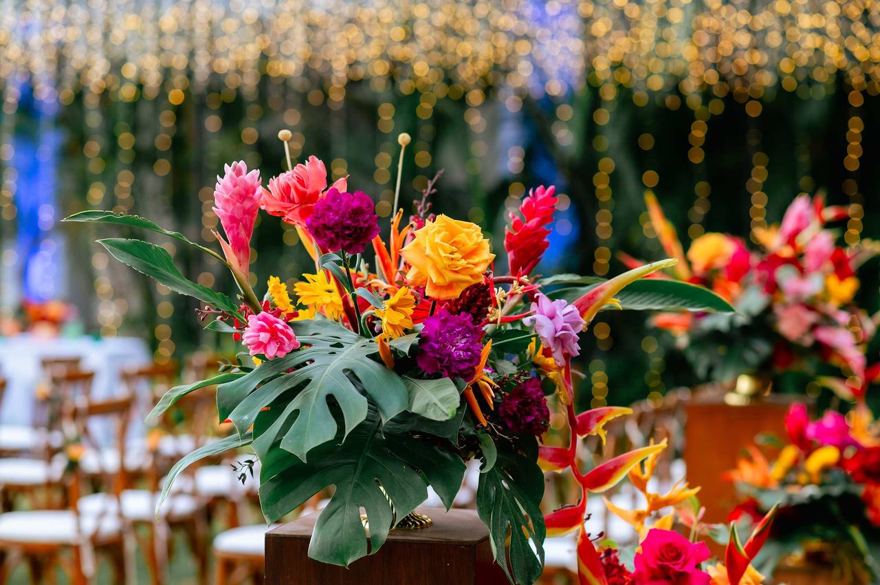 Vivid tropical centrepiece of heliconia, ginger and monstera for a Villa Aye reception, designed by Wedding Flowers Phuket